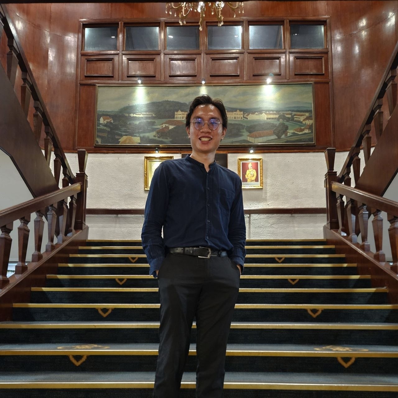 Abel standing on a wood-panelled staircase